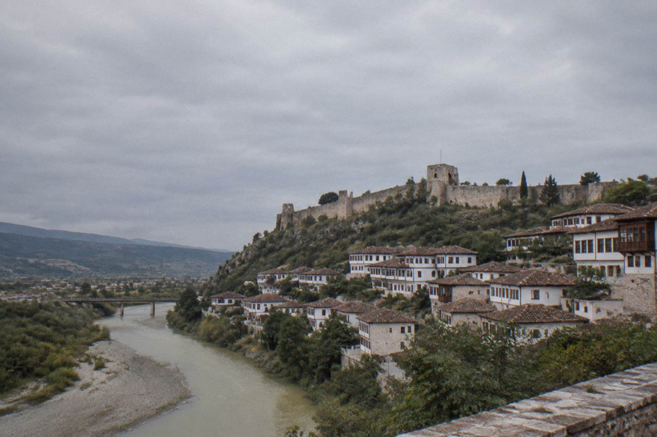 Ottoman houses stacked on a hillside above a river in a quiet historic town