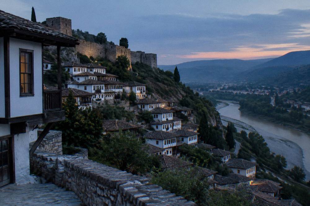 White Ottoman houses stacked on a hillside above the Osum River in Berat