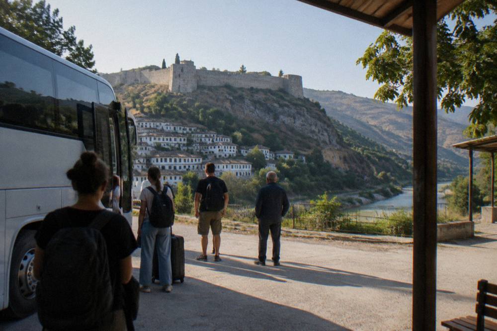 Passengers waiting beside a coach at a small bus terminal in Albania