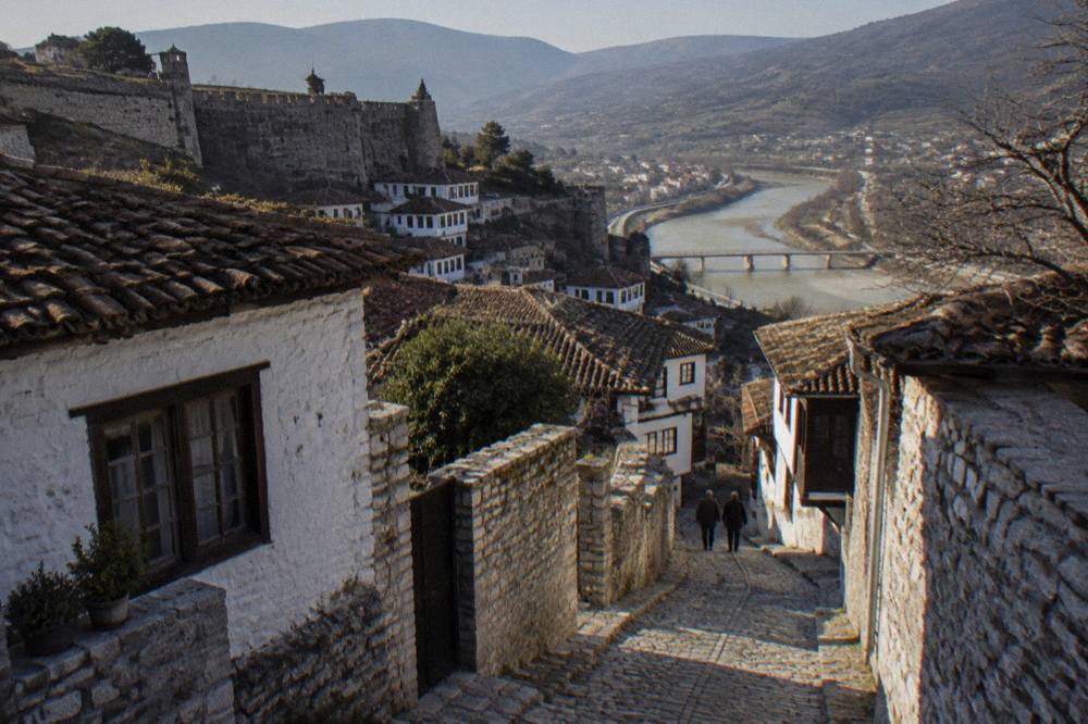A narrow cobbled lane between stone and whitewashed houses in Berat