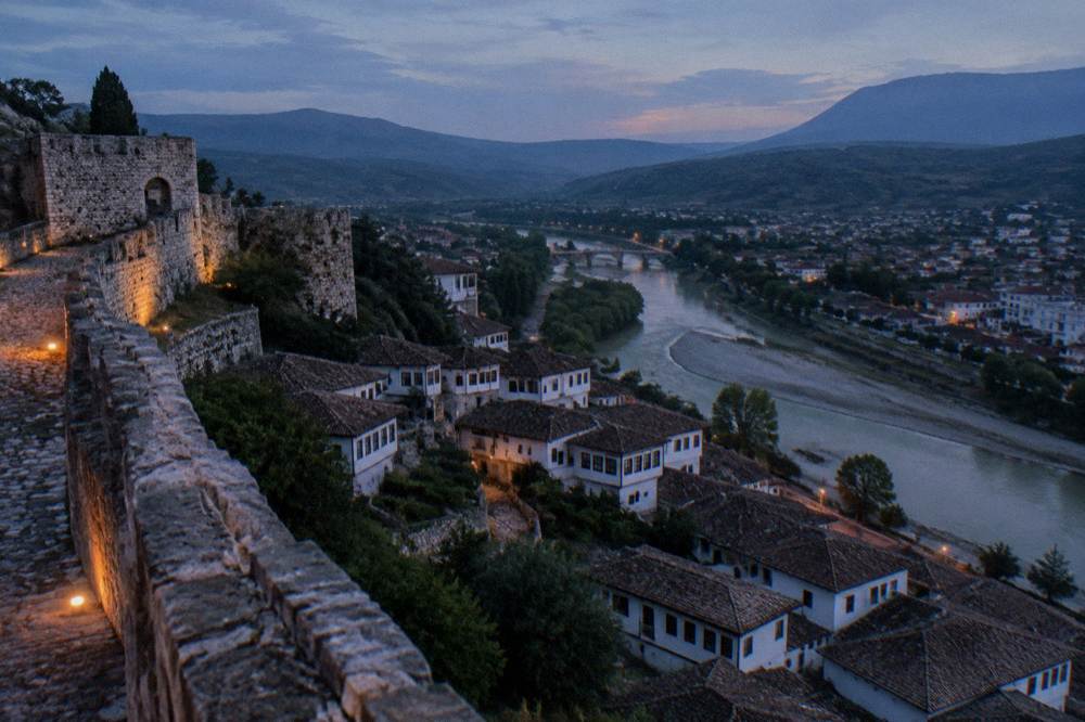 White Ottoman houses stacked on a hillside above the Osum River in Berat, Albania