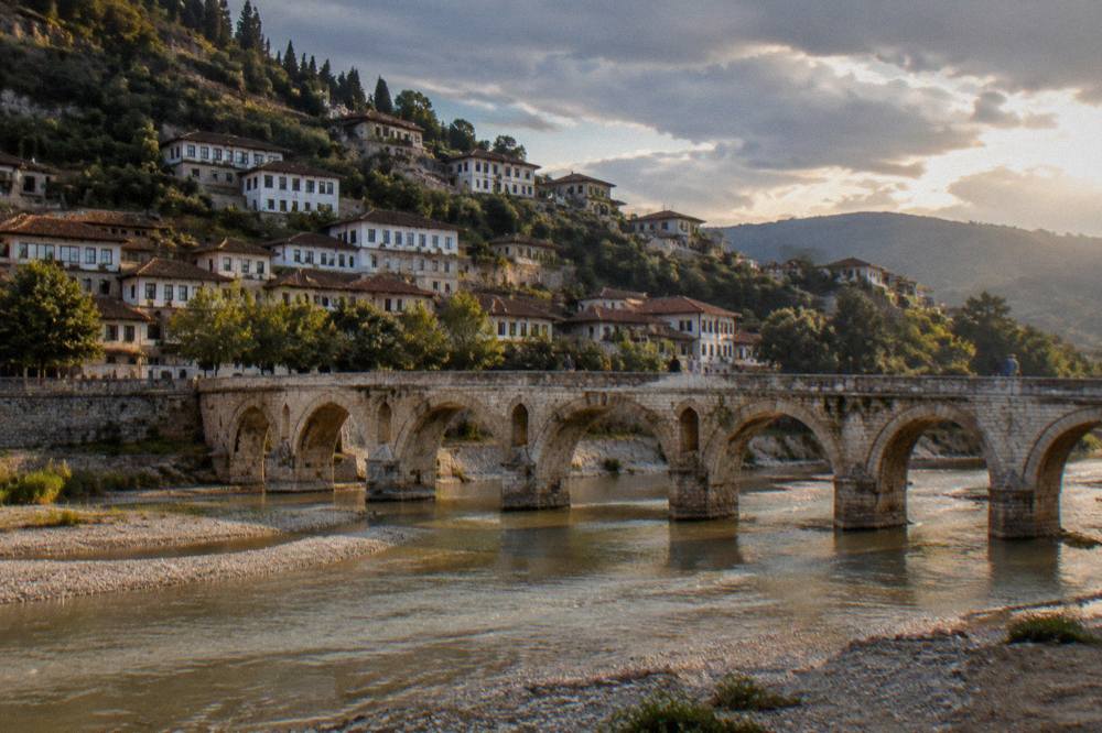 Gorica Bridge and stone houses along the riverbank in Berat at dusk