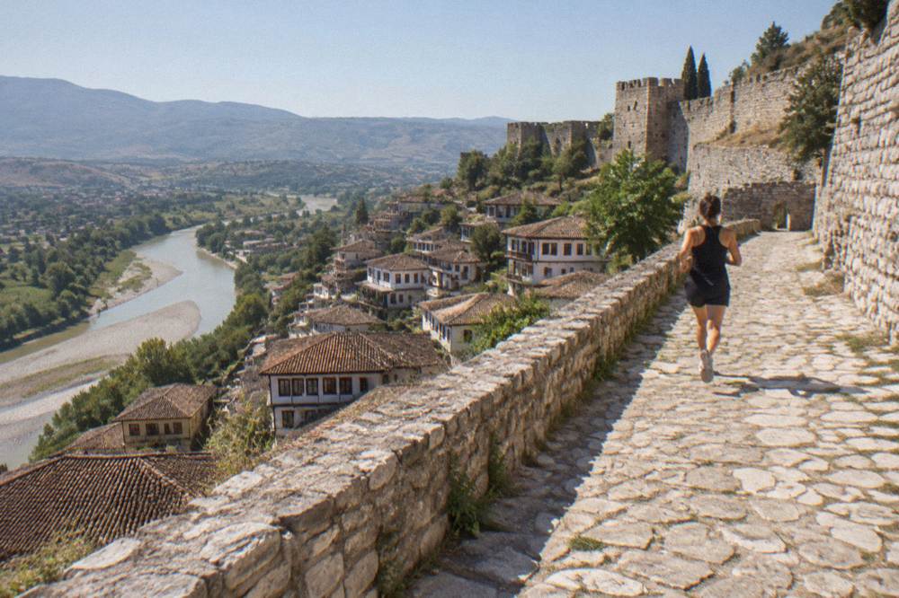 Ottoman-era houses stacked on a hillside above a river in Berat