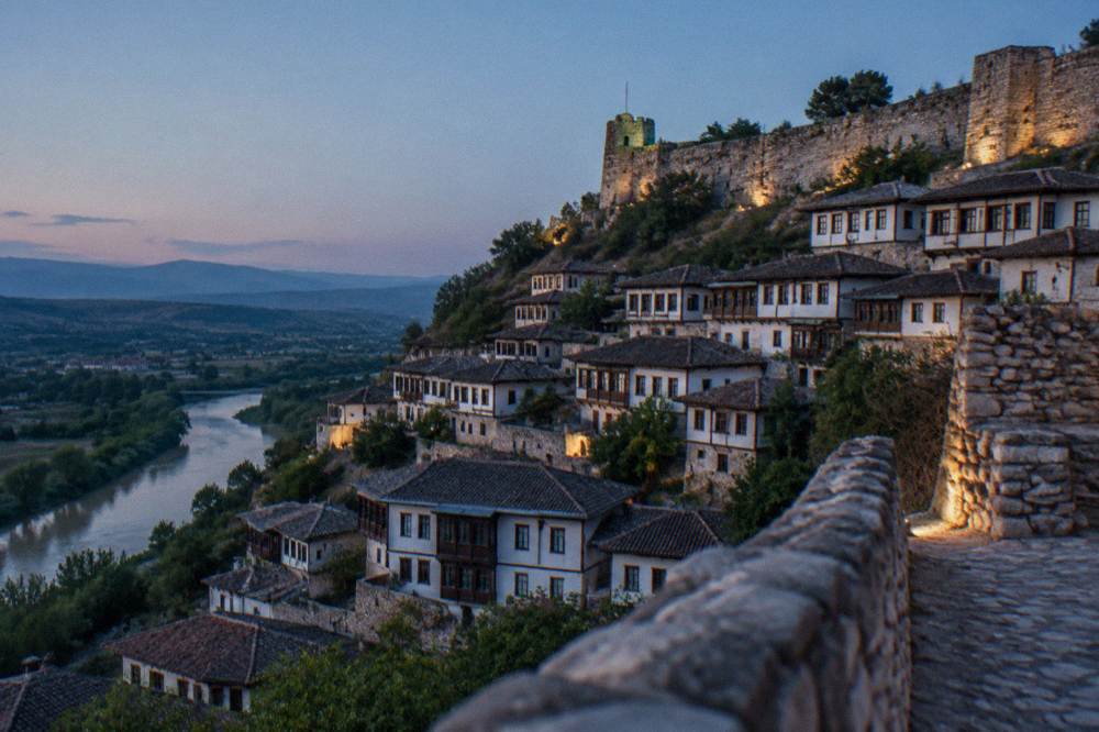 White Ottoman houses of Berat stacked on a hillside under a clear sky
