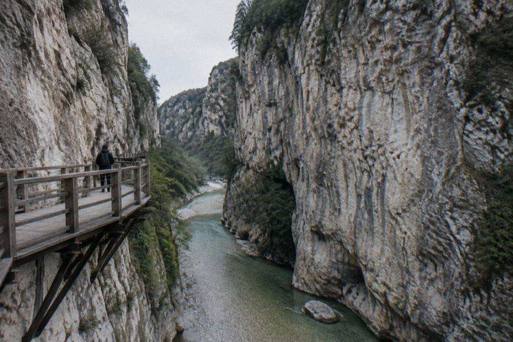 Limestone walls of Osumi Canyon rising above green river water