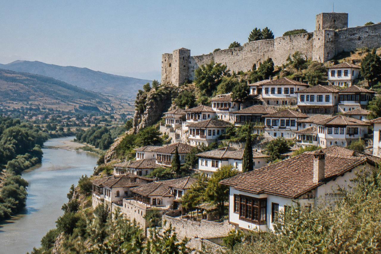 White Ottoman houses of Berat stacked on a hillside under a clear sky