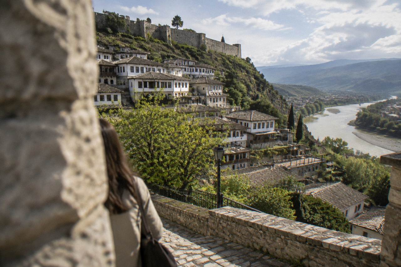 White Ottoman houses of Berat stacked on a hillside above the Osum River in spring