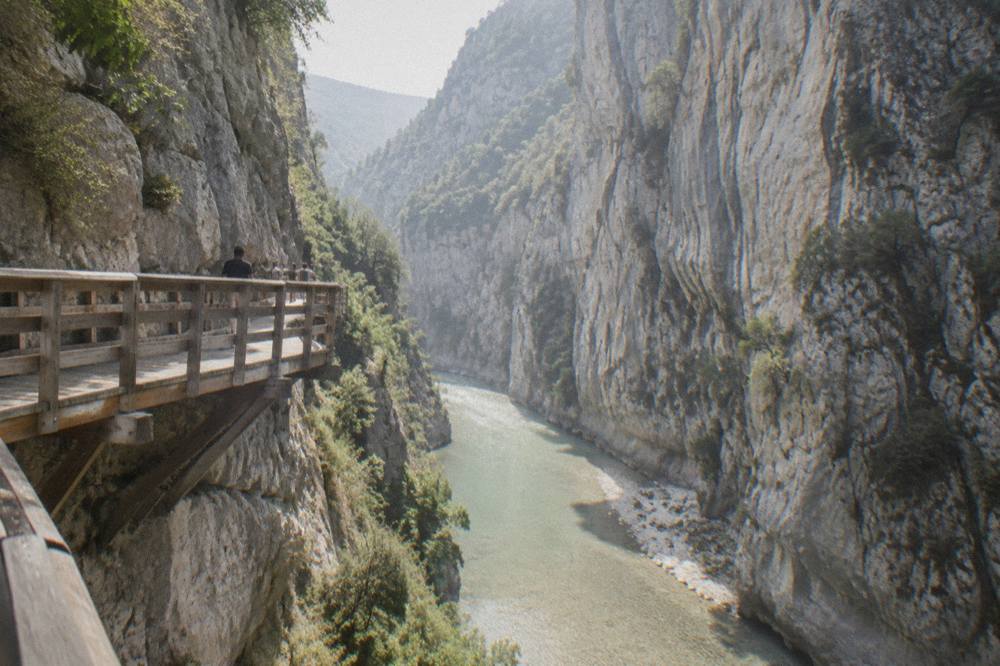 Steep limestone canyon walls above a green river winding through Osumi Canyon