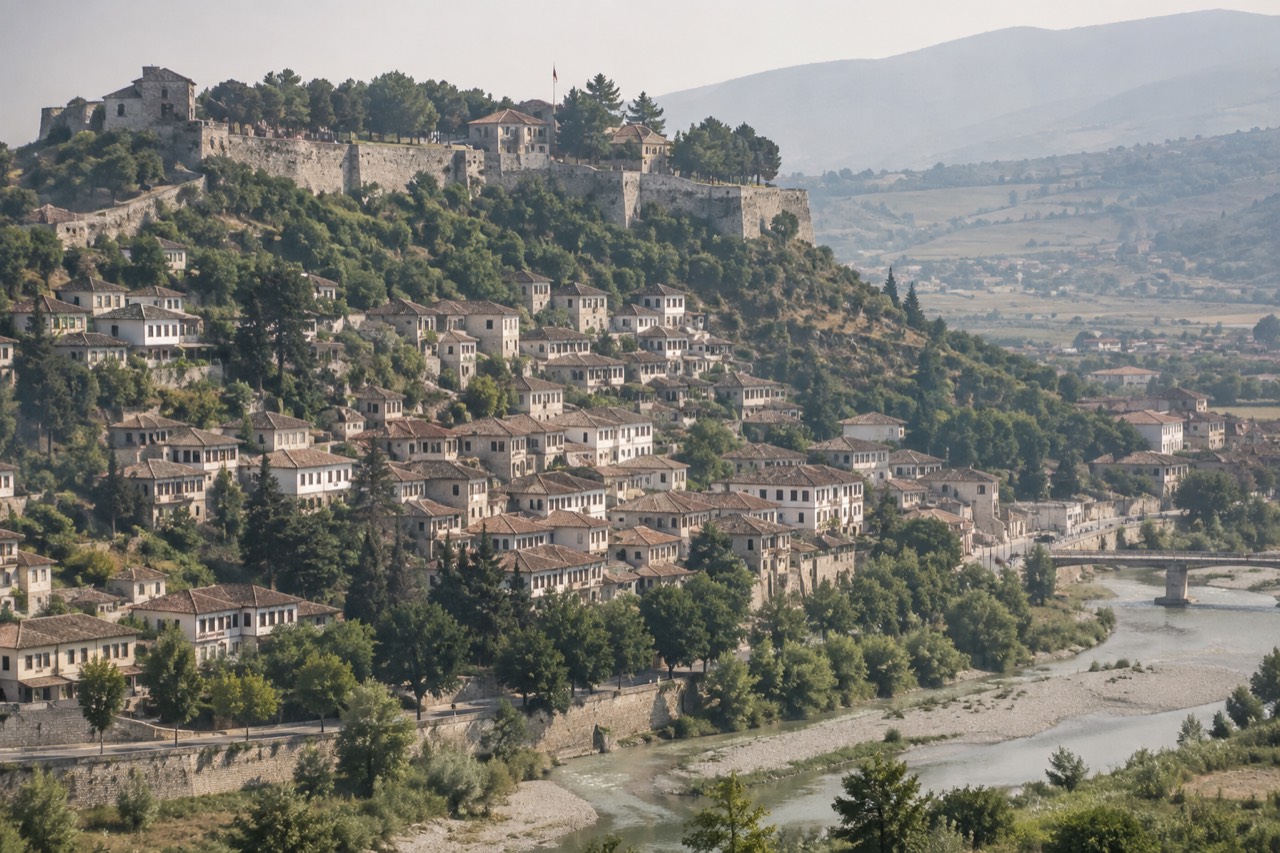 White Ottoman houses stacked on a hillside above a river in Berat, Albania