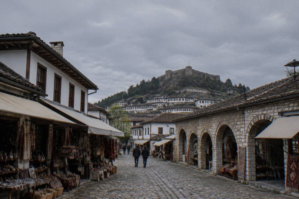 Stone lane and arched gate inside Berat castle quarter with old church walls