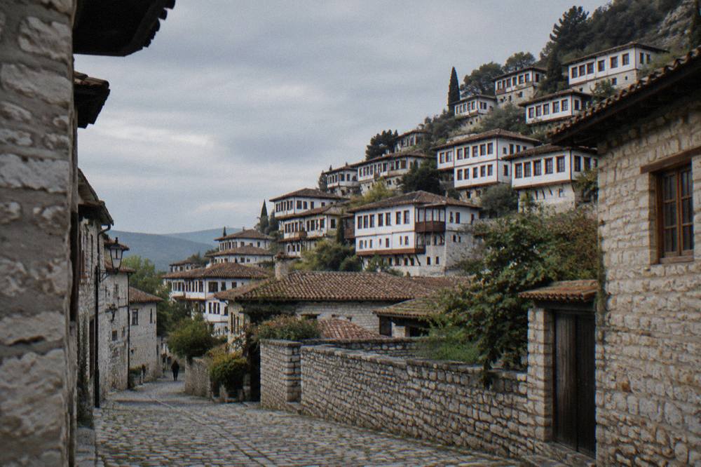 Stone houses and a cobbled lane in the Gorica quarter of Berat under soft evening light