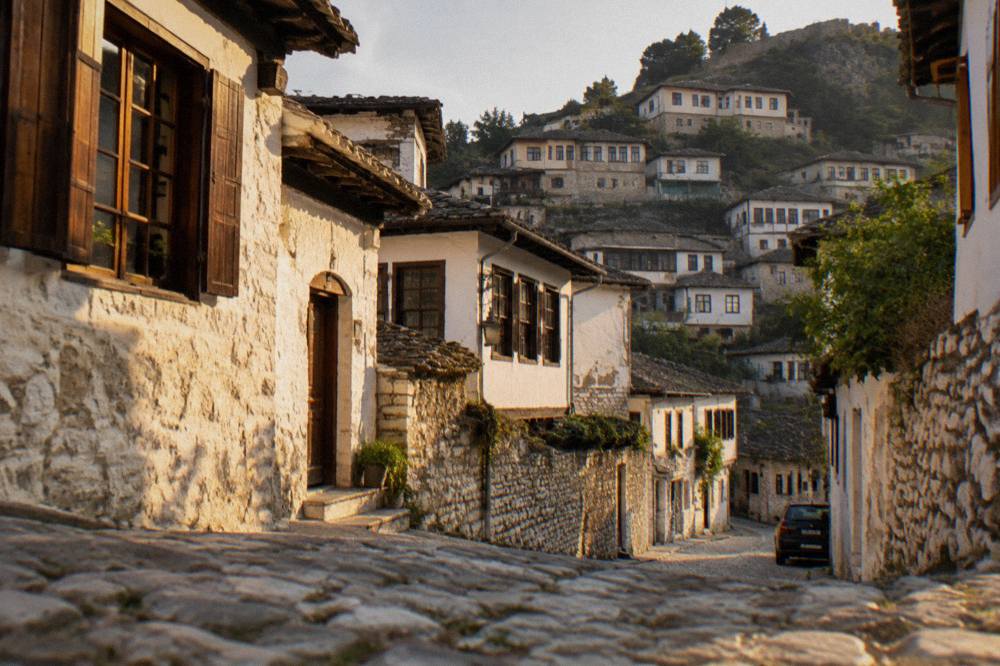 Cobbled stone street between whitewashed Ottoman houses in Berat with wooden window shutters