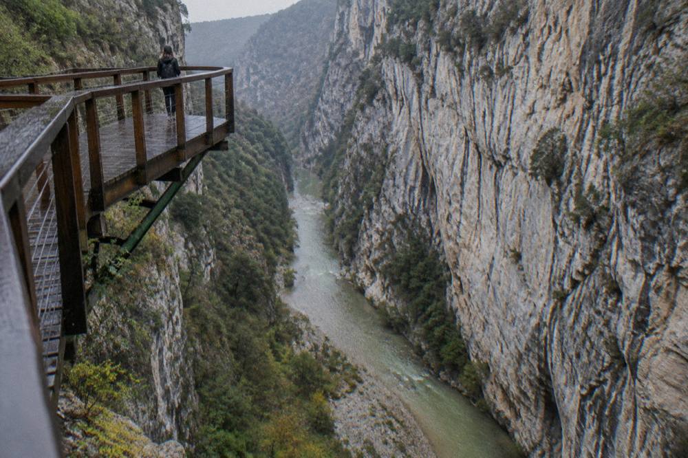 Limestone canyon walls rising above a narrow green stretch of the Osum River