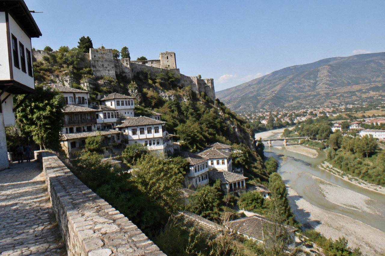 The Osum River flowing beneath stone houses stacked on a hillside in Berat