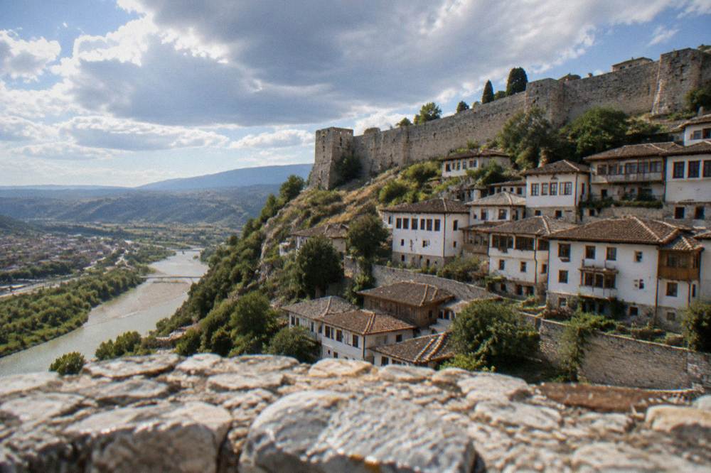 White Ottoman houses stacked on a hillside above the Osum River in Berat