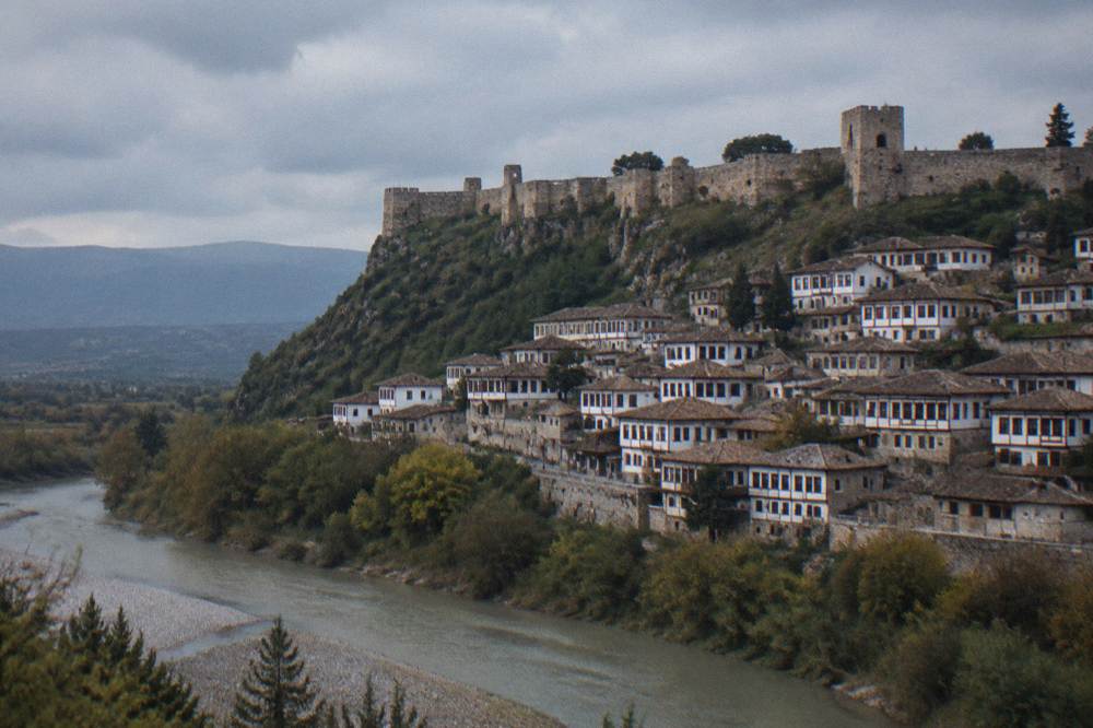 White Ottoman houses stacked on a hillside above the Osum River in Berat, Albania