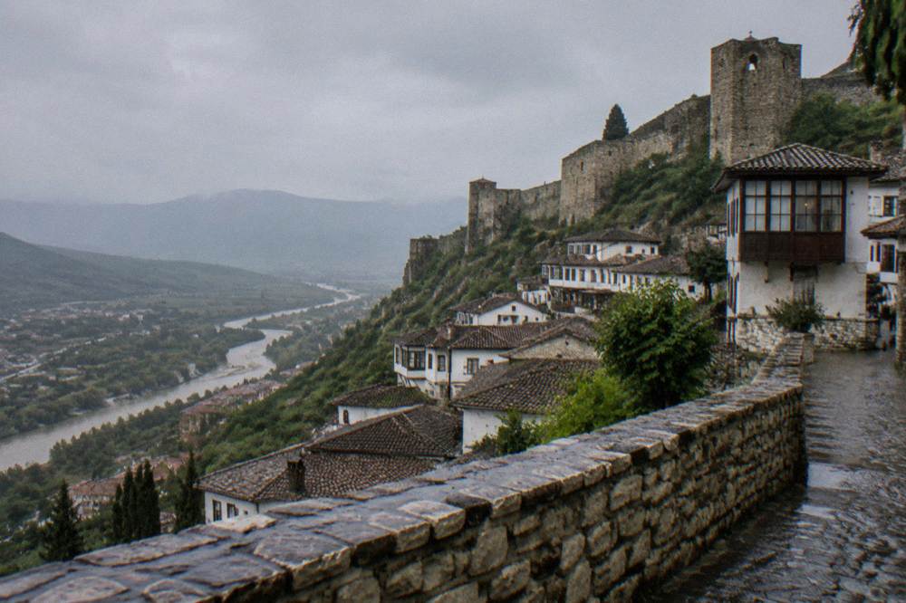 Stone fortress walls and towers rising above whitewashed Ottoman houses on a hillside