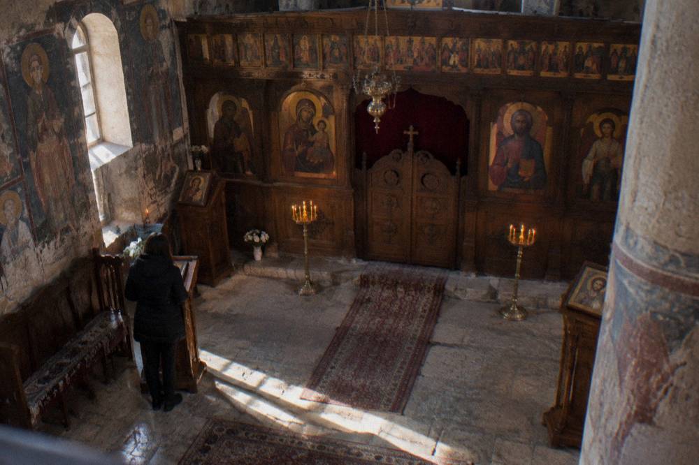 Old church interior with wooden iconostasis and painted panels