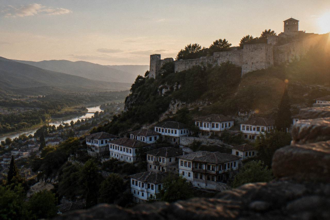 Stone fortress walls and towers rising above whitewashed Ottoman houses on a hillside