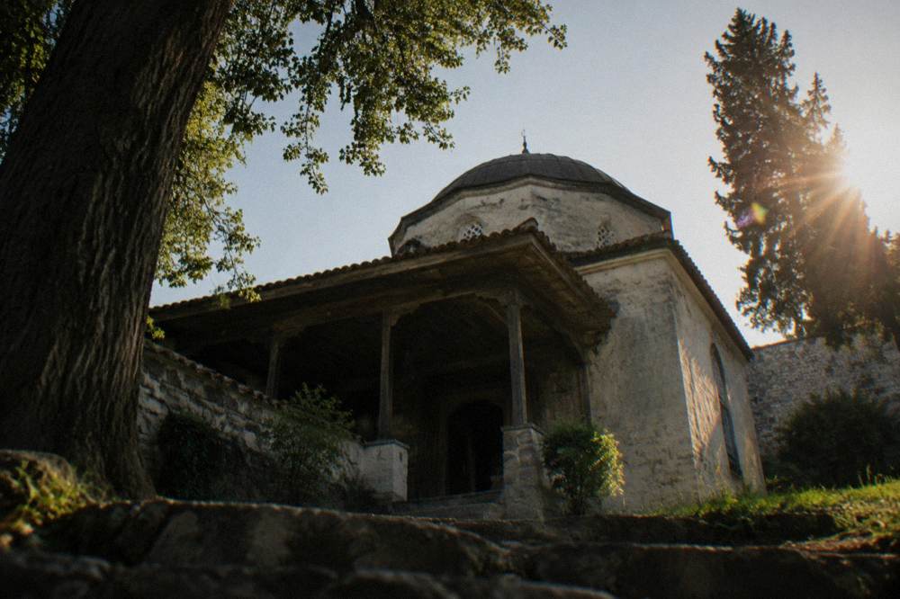 A dim interior with carved wooden ceiling details inside an old tekke room