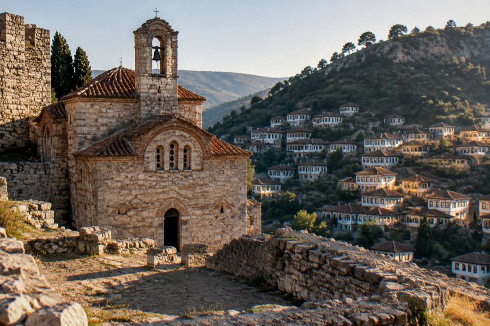 Warm evening light falling across the many windows of Mangalem's hillside houses