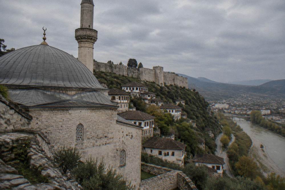 Close view of a stone mosque wall and grey lead dome against the sky in Berat