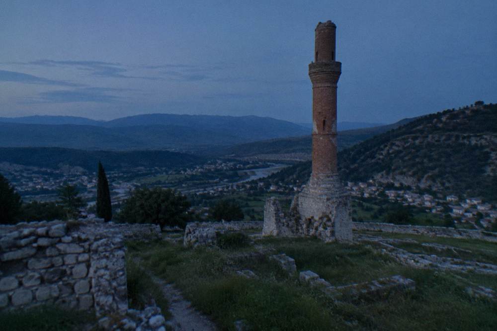 Round brick minaret of the ruined Red Mosque standing against a blue sky