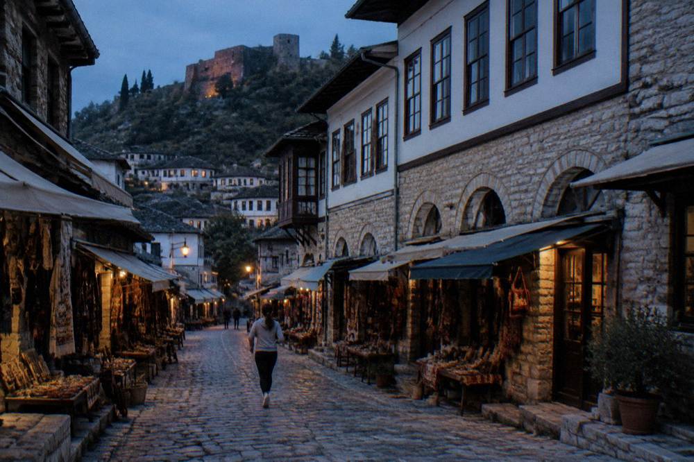 A historic stone house facade in Berat's old town with rows of white-framed windows