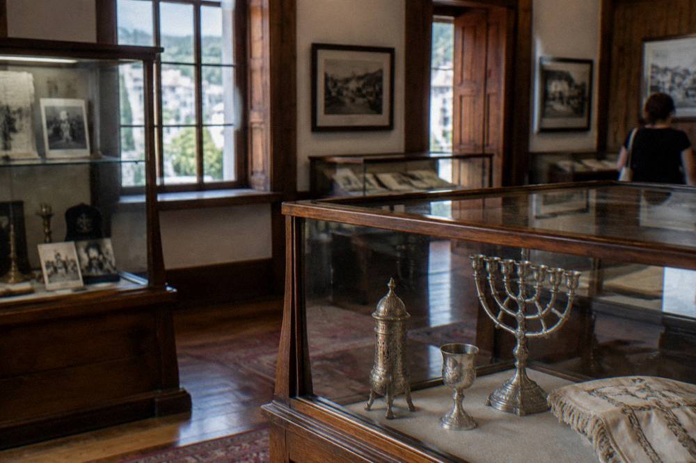 Interior of a small museum hall with wooden display cases and framed exhibits