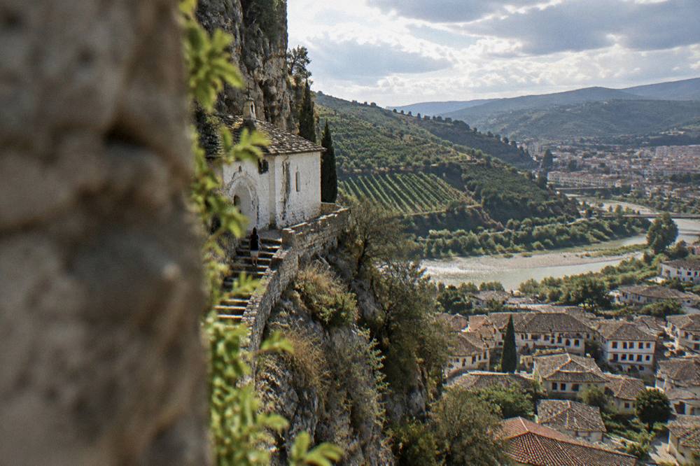 Vineyard rows on a hillside above the Osum valley with the town of Berat in the distance