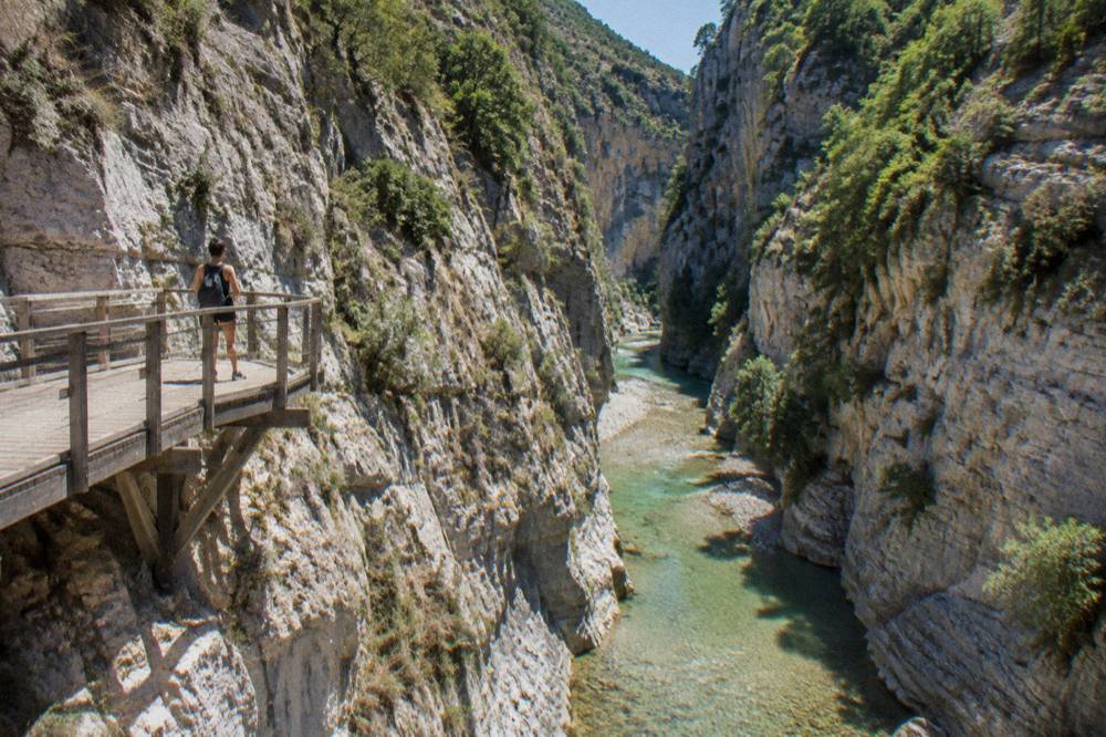 The steep limestone walls of Osumi Canyon above a green river in Skrapar, Albania