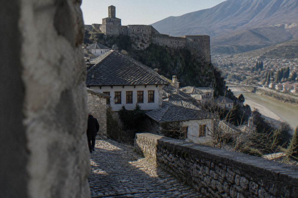 A hilltop fortress wall overlooking a river valley town