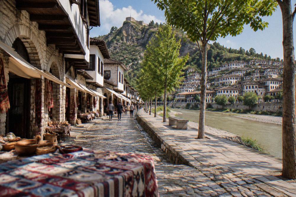 Flat tree-lined pedestrian promenade in the new town of Berat with the old town rising across the river