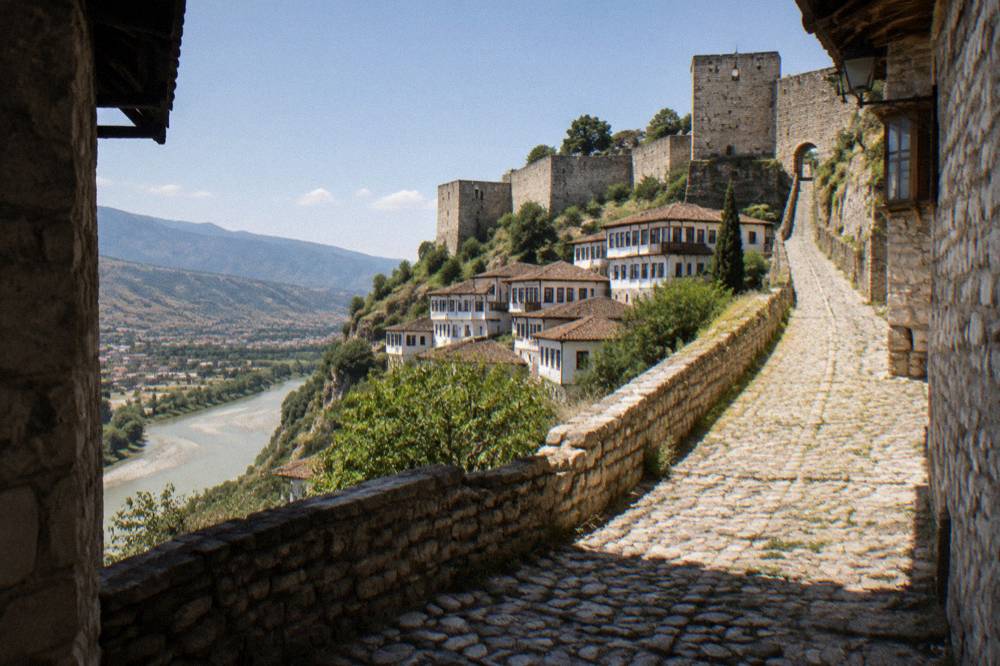 Steep cobbled lane rising toward the stone walls and towers of Berat Castle