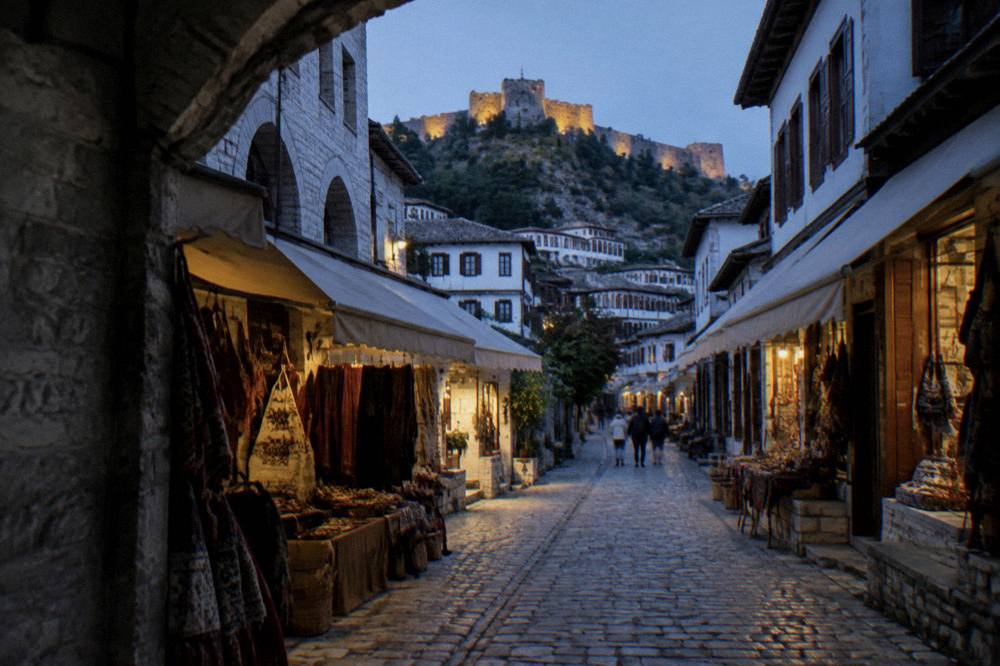 A cobbled lane with white stone houses and wooden window shutters in Berat old town