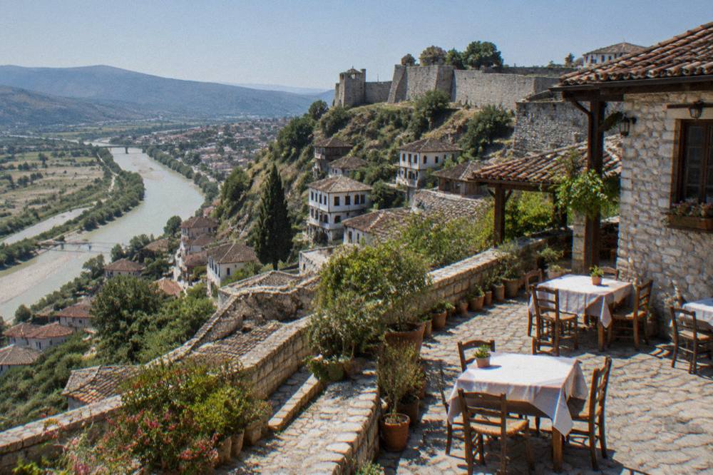Courtyard of a traditional stone guesthouse in Berat with tables set for eating outside