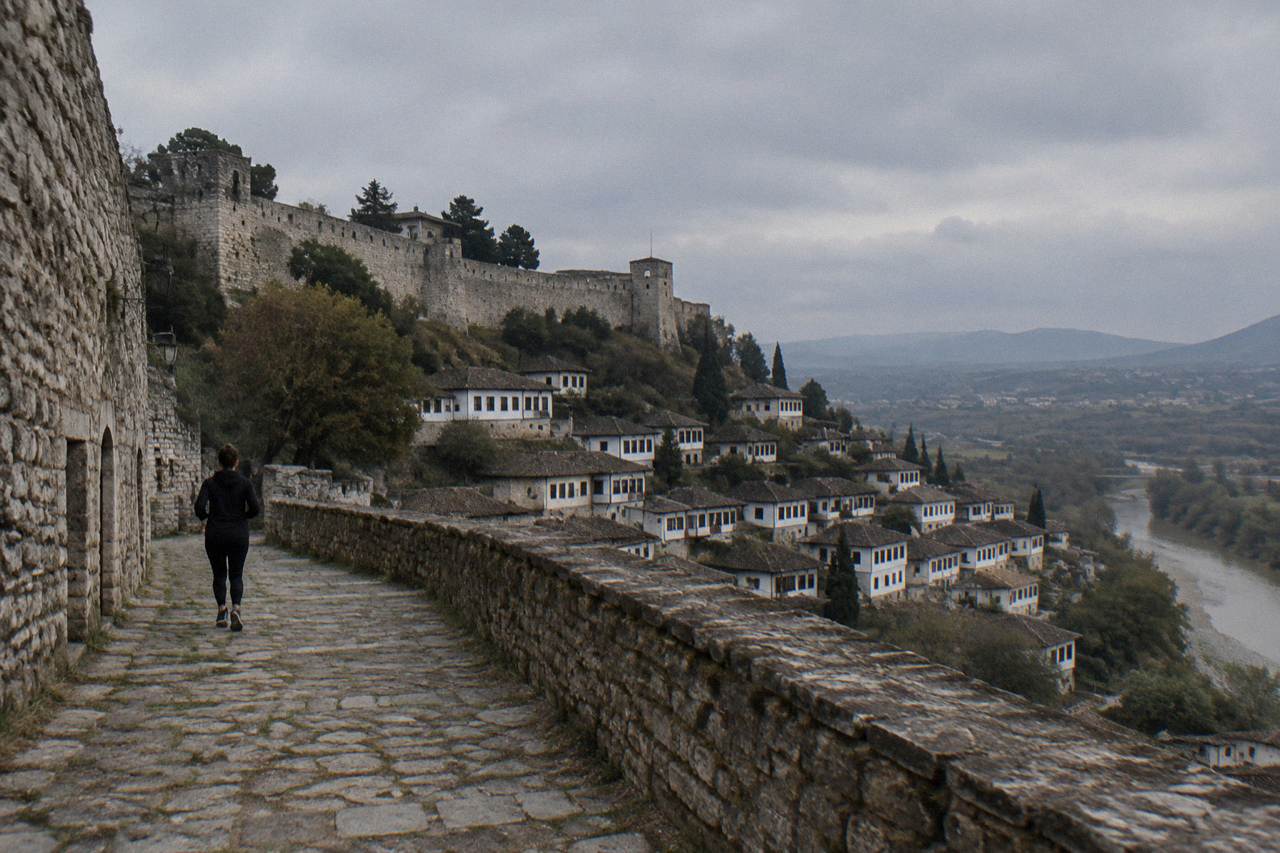 White Ottoman houses of Mangalem stacked on a hillside below Berat Castle above the Osum River