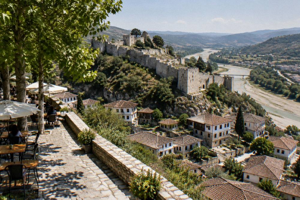Café terraces and plane trees along the evening promenade in Berat