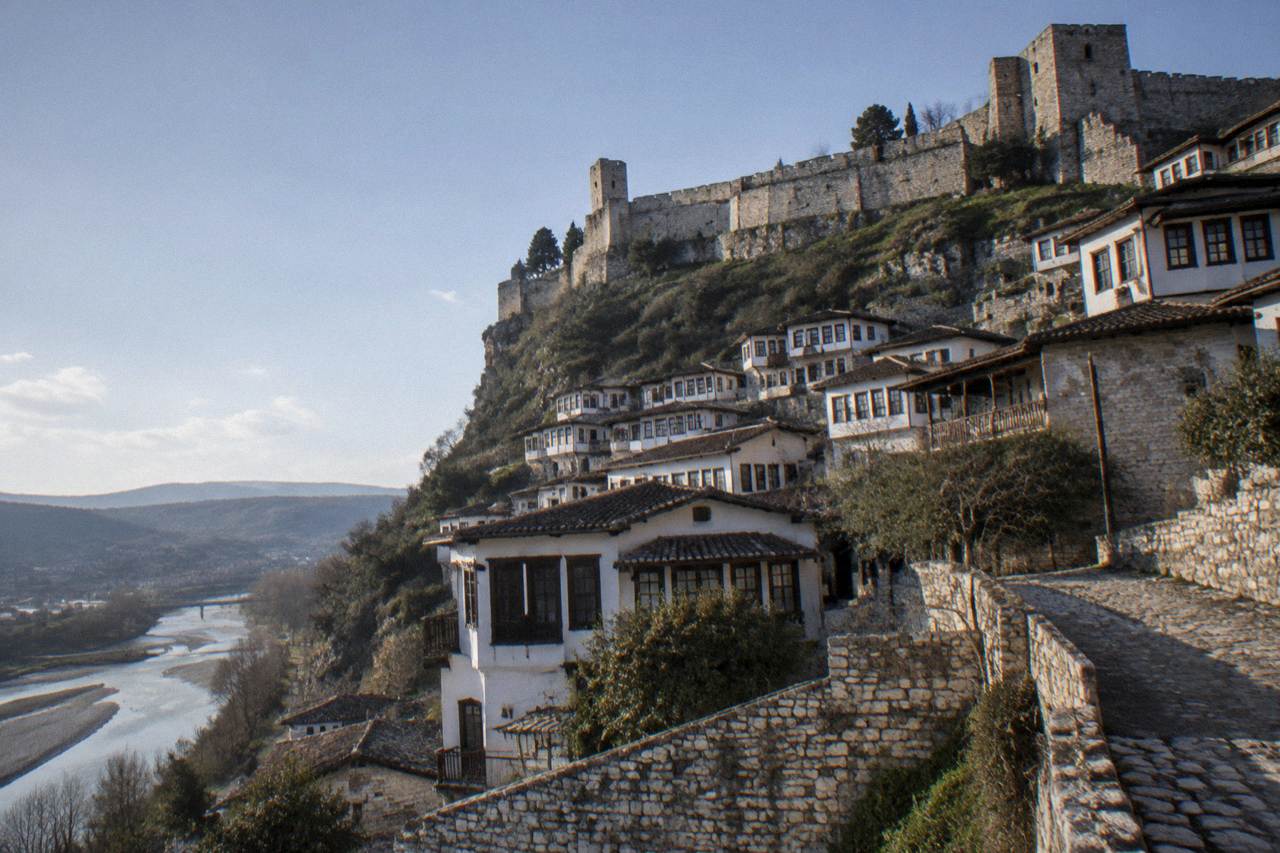White Ottoman houses stacked on a hillside above the Osum River in Berat