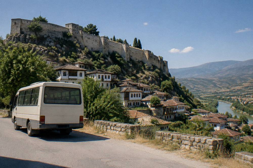 A small bus parked on a roadside with hills in the background in central Albania