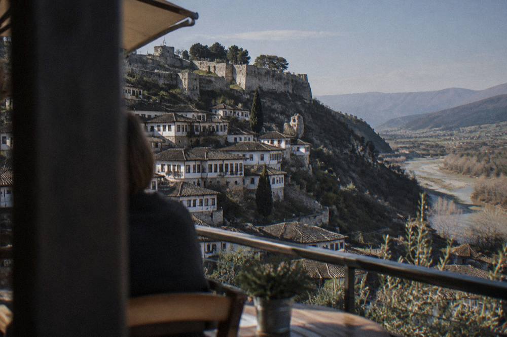 Guesthouse terraces overlooking a hillside of white Ottoman houses in Berat