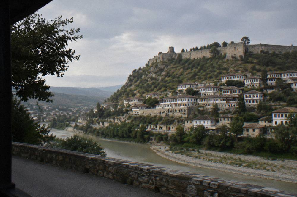 White Ottoman houses stacked on the hillside above the Osum River seen from a road viewpoint