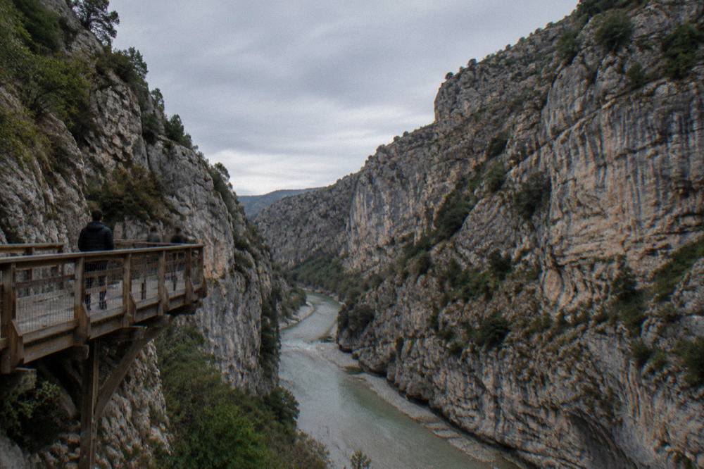 Steep limestone walls of Osumi Canyon with the green river running below