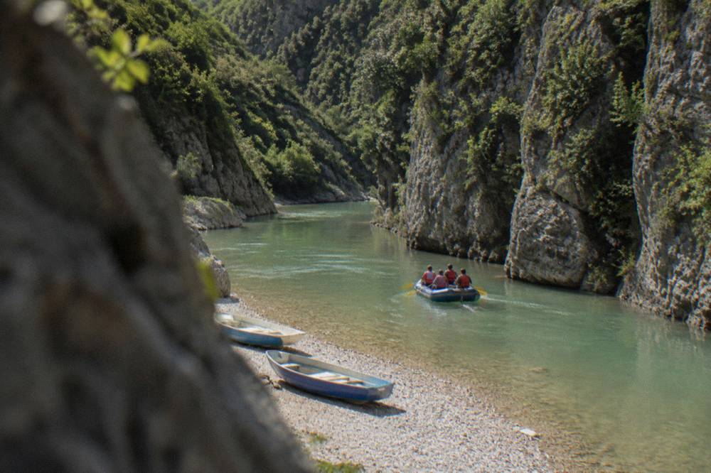 Inflatable rafts on green river water between steep canyon walls
