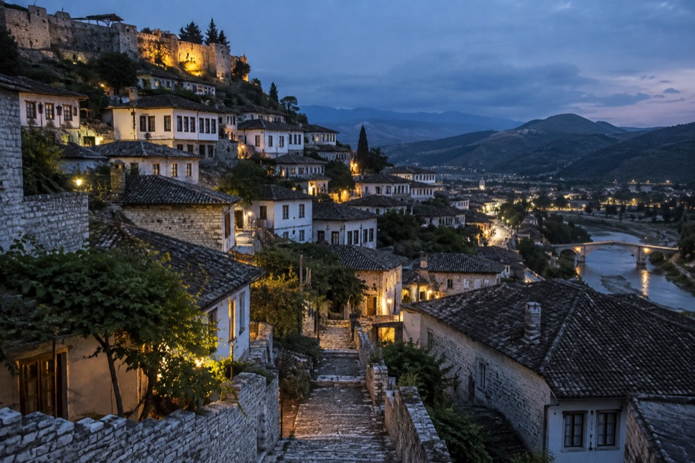 Stone houses of Berat's Mangalem quarter stacked on a hillside below the castle walls