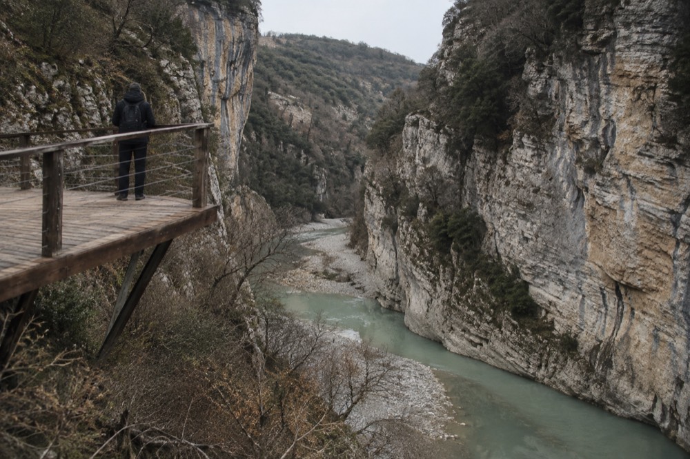Steep rock walls of Osumi Canyon above a green river bend