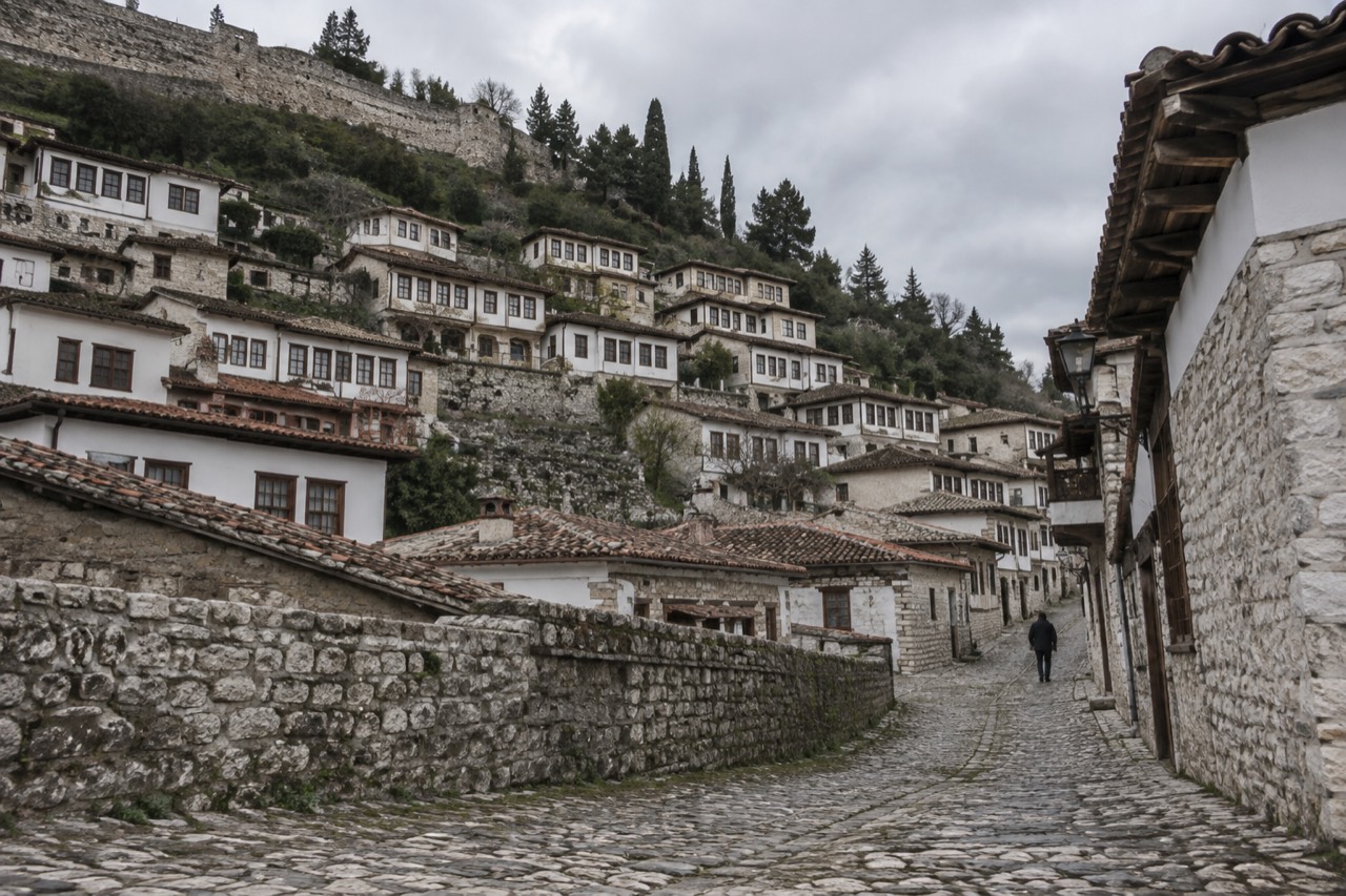 Stone houses of Berat's Mangalem quarter stacked on a hillside below the castle walls