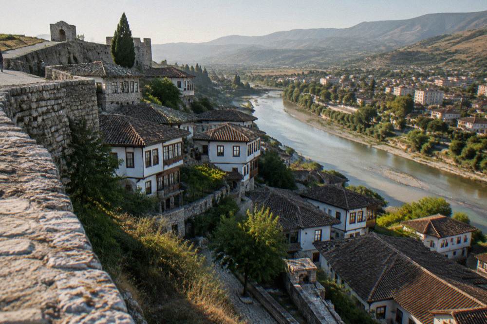 White Ottoman houses stacked on a hillside above a river in Berat, Albania
