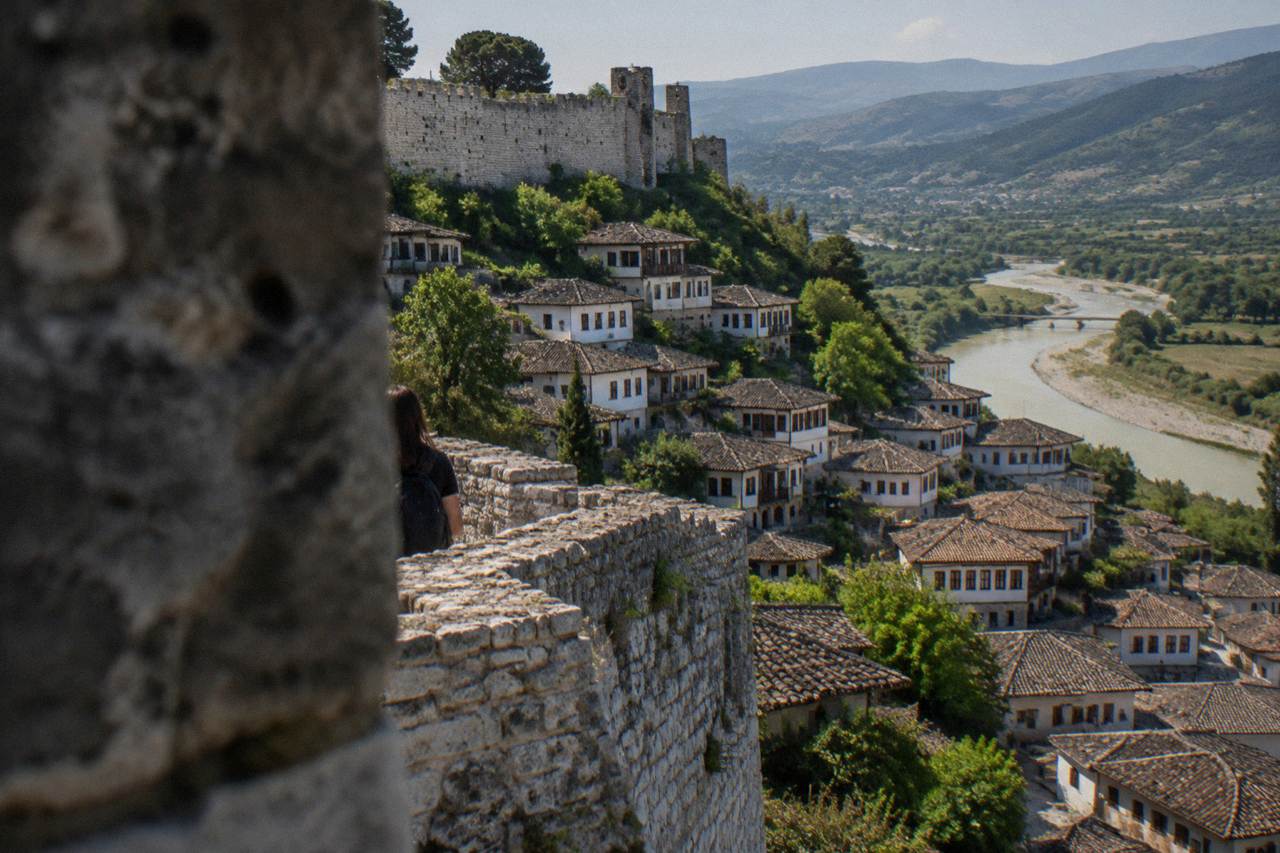 White Ottoman houses stacked on a hillside above a river in Berat, Albania