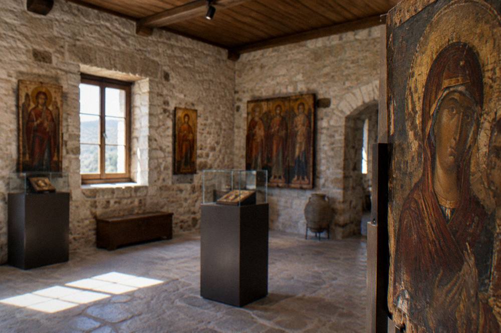 Interior of a stone museum hall with wooden ceilings and icons on display